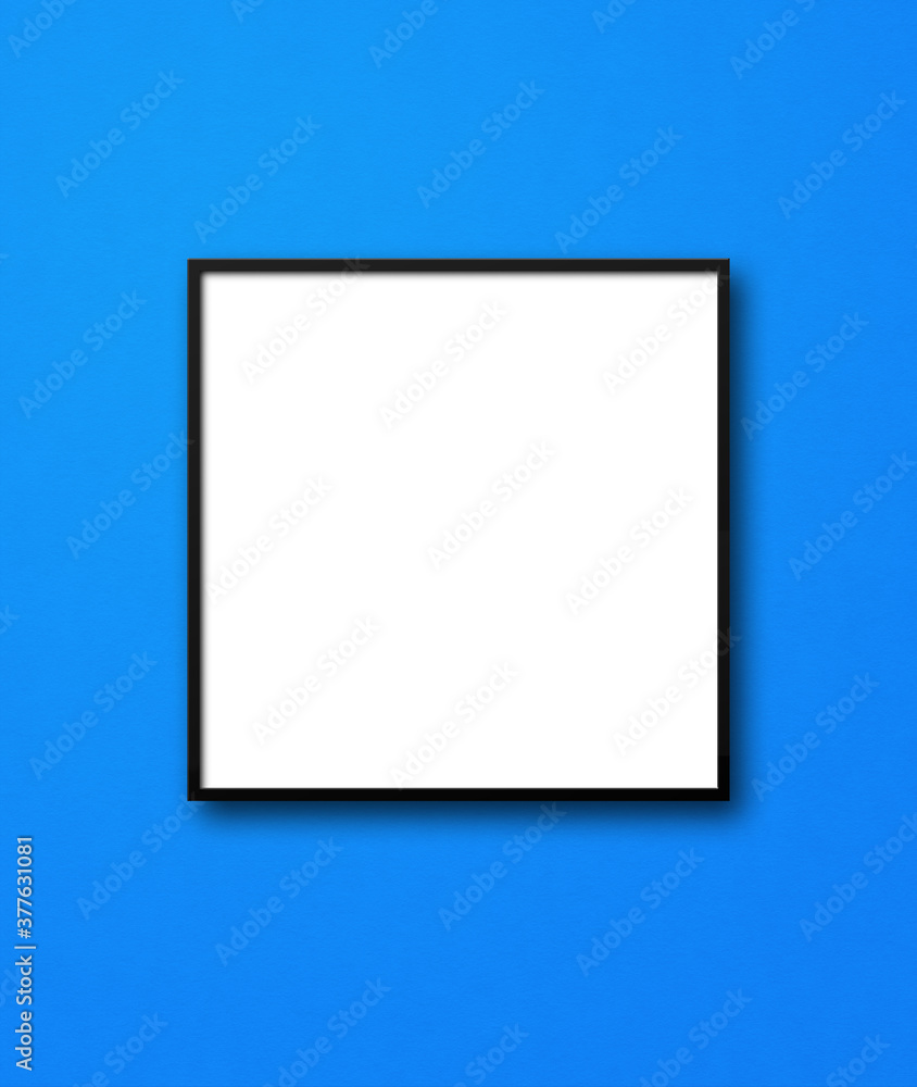 Black square picture frame hanging on a blue wall Black square picture frame hanging on a blue wall