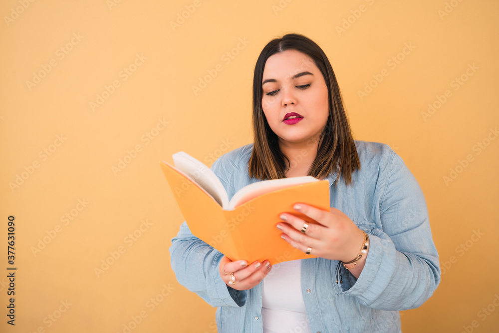 Fototapeta premium Young plus size woman reading a book.