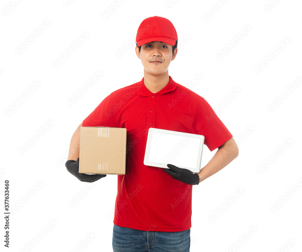 Young Delivery man in red uniform holding paper cardboard box and tablet computer mockup isolated on white background with clipping path. Young Delivery man in red uniform holding paper cardboard box and tablet computer mockup isolated on white background with clipping path.