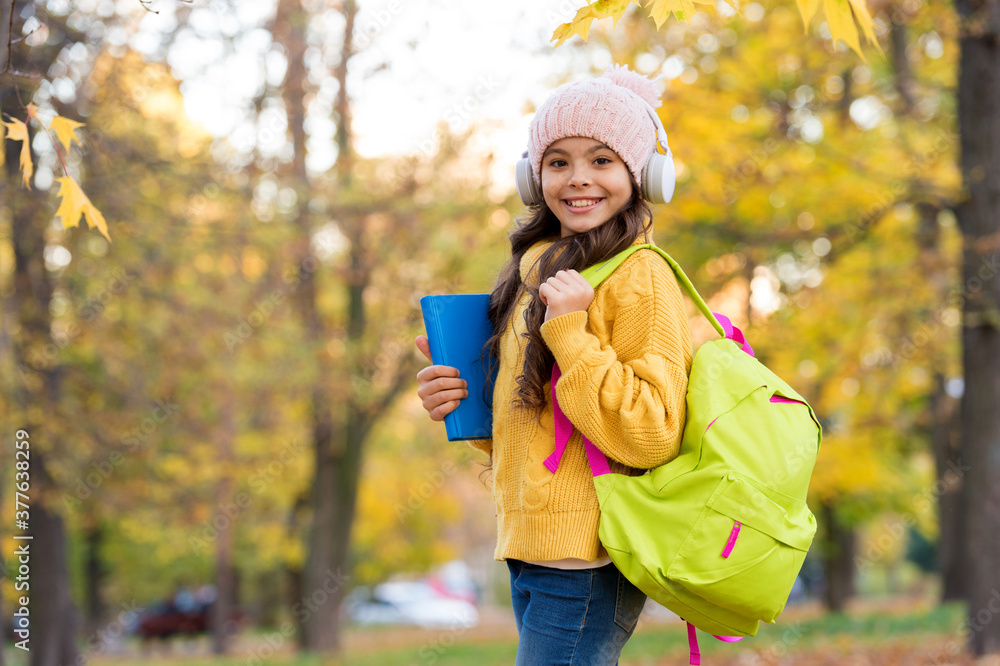 schoolgirl hold books and school bag while walking in park, education schoolgirl hold books and school bag while walking in park, education