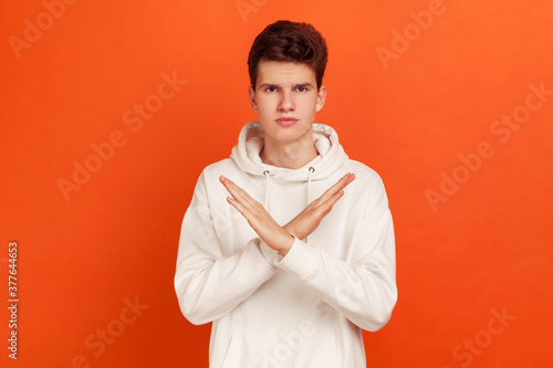 Canvastavla There is no way! Serious concentrated young man in stylish hoodie showing no gesture crossing arms, say no to bad habits, addiction