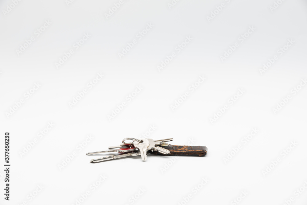 Bunch of keys with old and worn keychain isolated on white background.