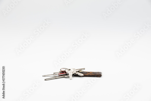 Bunch of keys with old and worn keychain isolated on white background.
