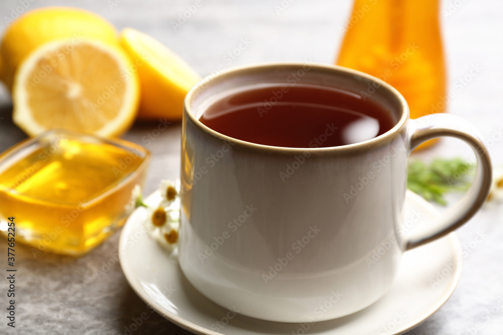 Tea with honey and lemon on grey table, closeup Tea with honey and lemon on grey table, closeup
