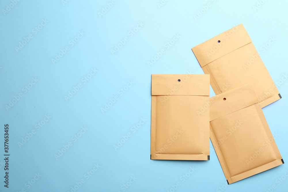 Kraft paper envelopes on light blue background, flat lay. Space for text Kraft paper envelopes on light blue background, flat lay. Space for text