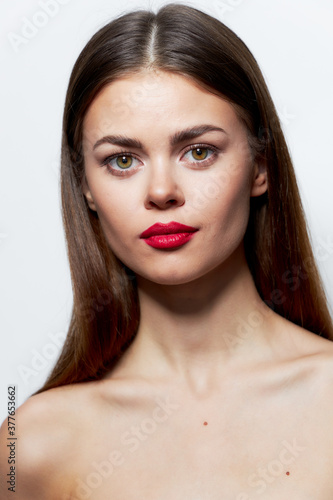 Woman Red lips bared shoulders look ahead clear skin light 