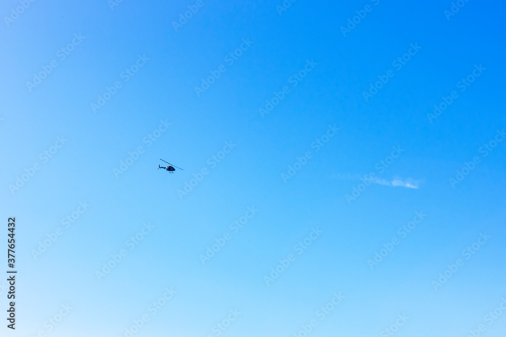 A helicopter flying in the clear blue sky