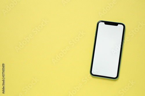 MYKOLAIV, UKRAINE - JULY 07, 2020: iPhone 11 on yellow background, top view. Mockup for design photo