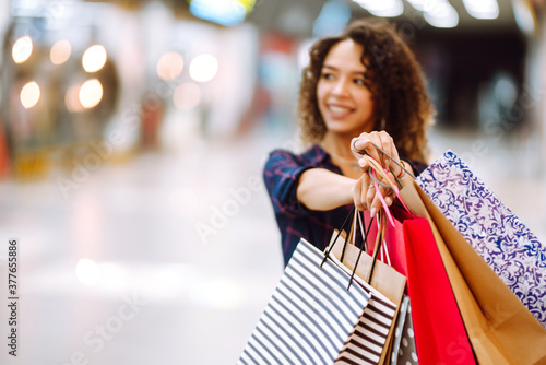 Shopping bags in the hands. Young woman with packages after shopping. Purchases, black friday, discounts, sale concept.