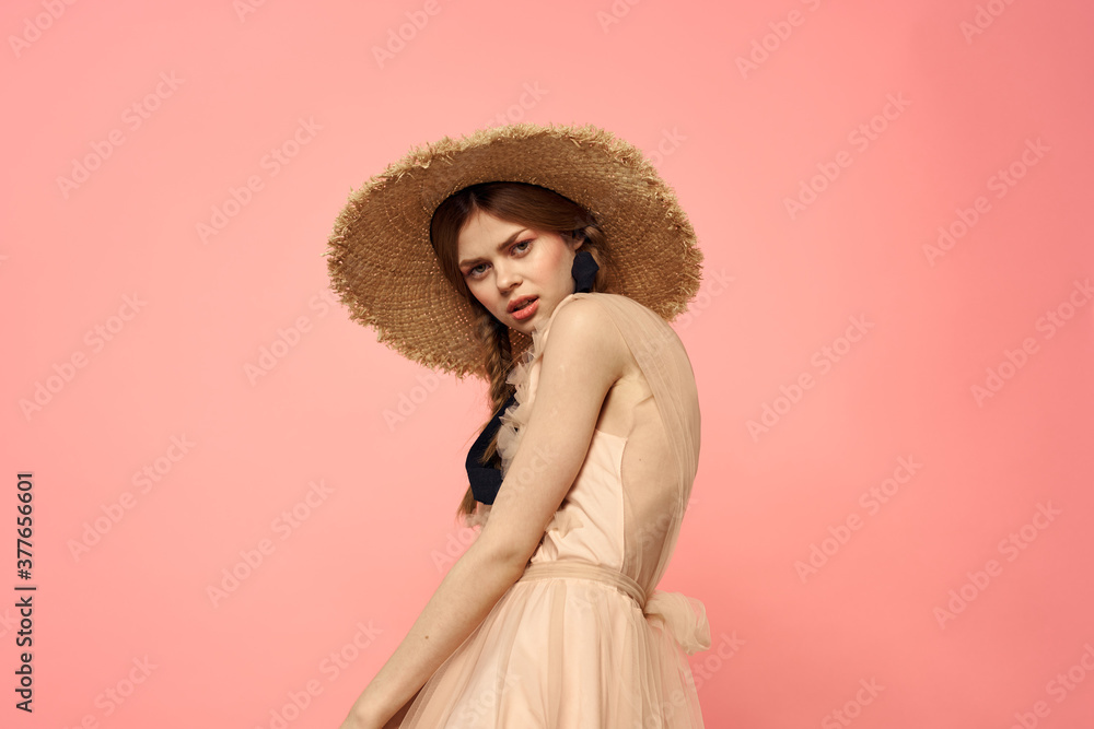 Fashionable woman in dress and hat with black ribbon on pink background cropped view of model emotions fun
