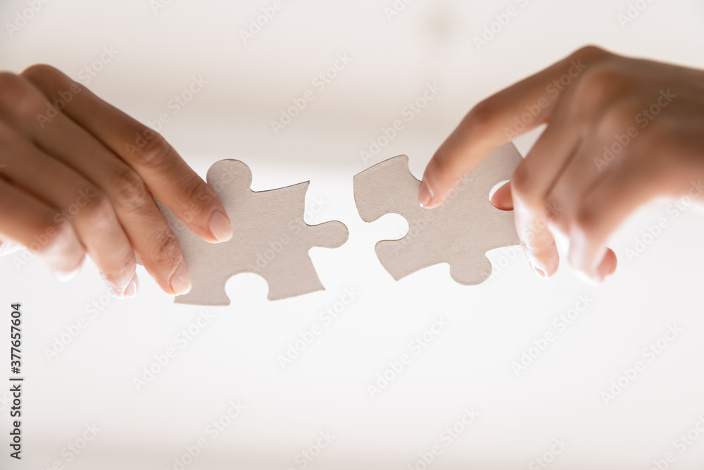 Close up of people assemble jigsaw puzzle find business solution or perfect match. Diverse employees workers put join pieces, participate in teambuilding activity. Teamwork, collaboration concept. Close up of people assemble jigsaw puzzle find business solution or perfect match. Diverse employees workers put join pieces, participate in teambuilding activity. Teamwork, collaboration concept.