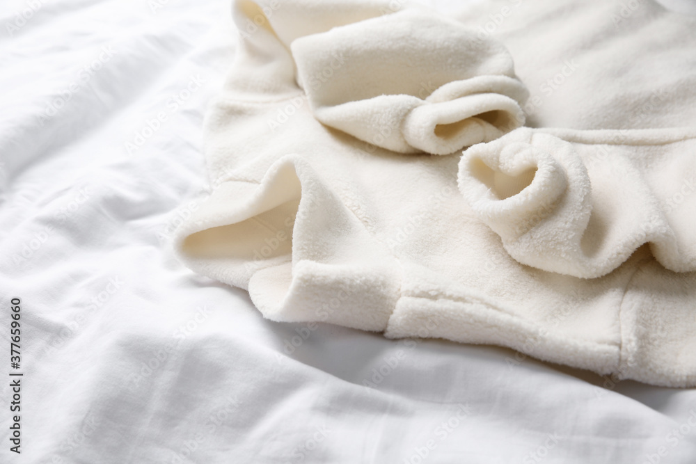 Warm fleece sweater on white crumpled fabric, closeup Warm fleece sweater on white crumpled fabric, closeup