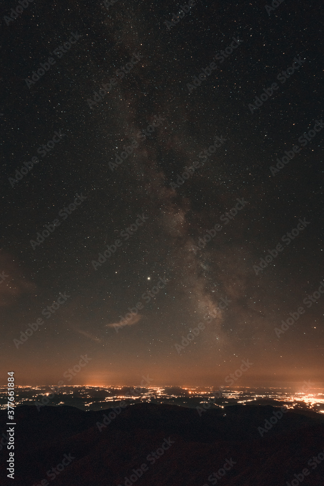 Milky way galaxy and the city from the mountain
