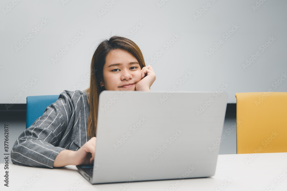 Woman working by laptop in office with happy Woman working by laptop in office with happy