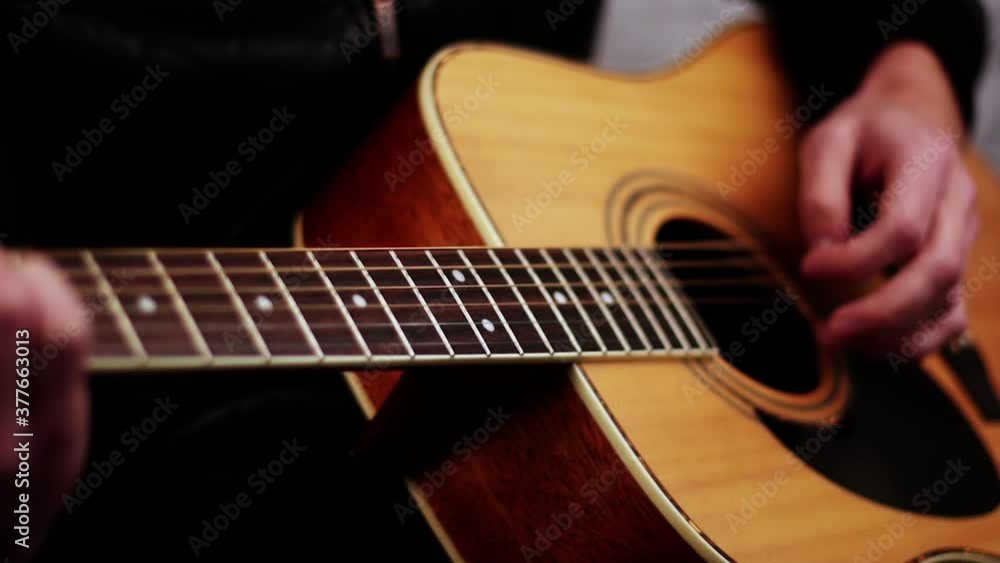 Young musician playing chords on acoustic guitars strings Young musician playing chords on acoustic guitars strings
