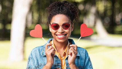 Black Girl Holding Two Paper Hearts Posing Standing In Park