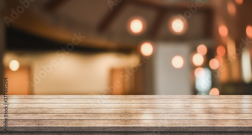 Empty wooden table top with lights bokeh on blur restaurant background  