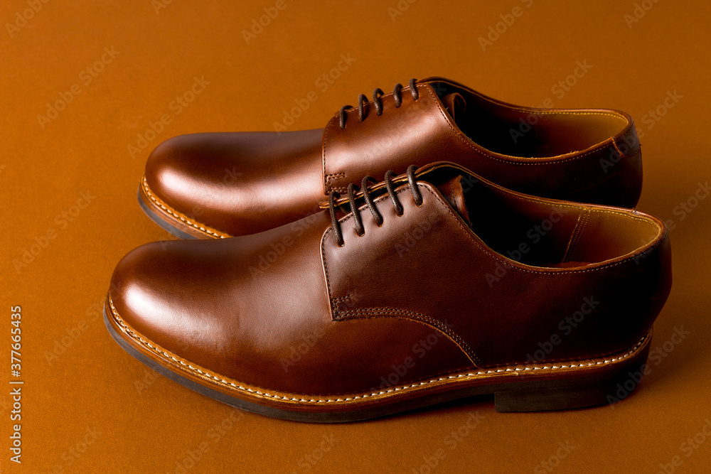 Brown oxford shoes on paper background.