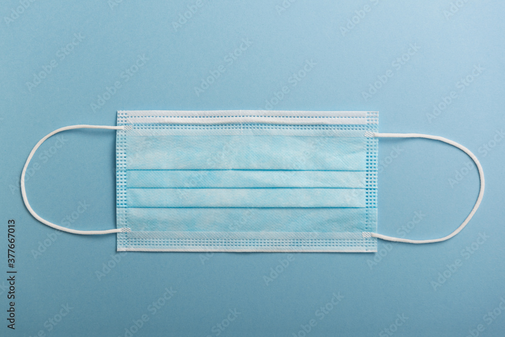 Surgical mask on a blue background. Coronavirus protection concept (COVID19). Surgical mask on a blue background. Coronavirus protection concept (COVID19).