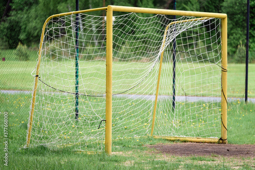 Yard football goal painted yellow to play on the green grass.