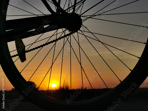 bike at sunset. Outline of a Bicycle wheel in the sun