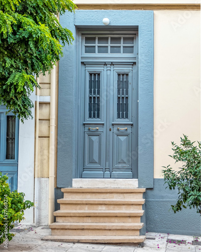 A vintage house front door and plant by the sidewalk, Athens, Greece