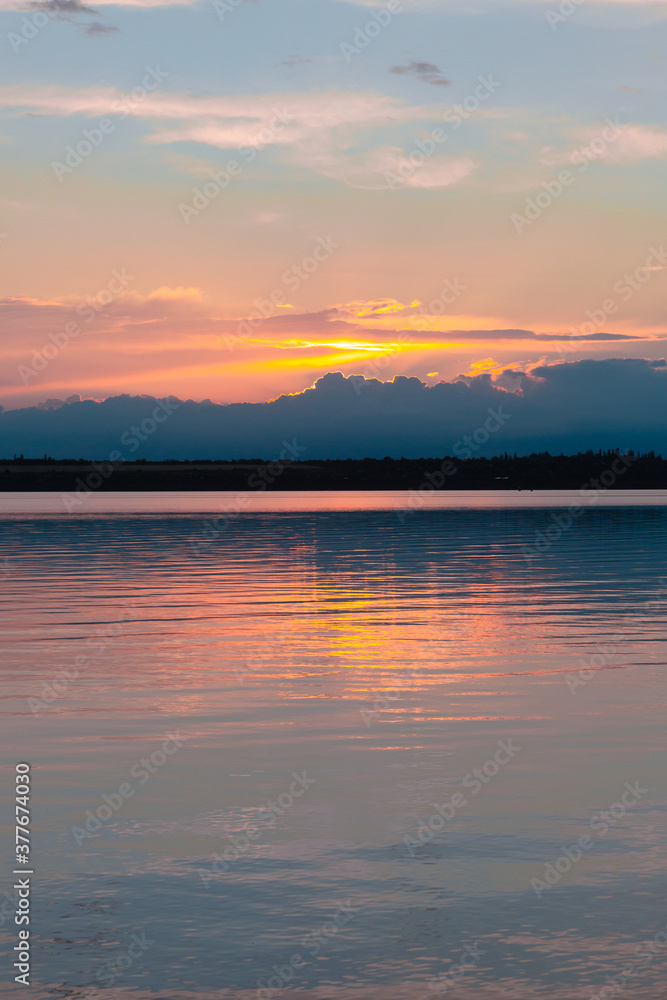 Obraz premium colored sunset over the river, with sky reflection