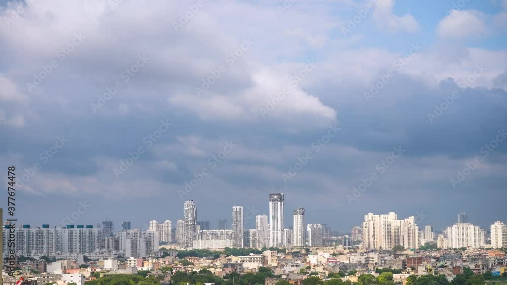 Aerial timelapse of gurgaon delhi cityscape with monsoon clouds casting shadows on high rise apartments and buildings showing passage of time and rapid growth of real estate and infrastructure Aerial timelapse of gurgaon delhi cityscape with monsoon clouds casting shadows on high rise apartments and buildings showing passage of time and rapid growth of real estate and infrastructure