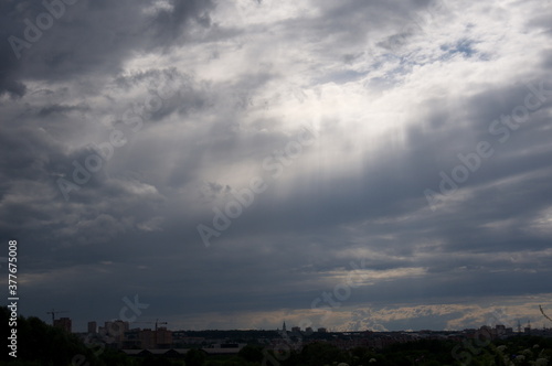 sky with breaking sun rays over the city