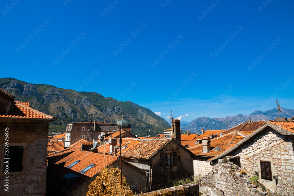 View of the old European city of Kotor, red tiled roofs and the Adriatic sea coast with mountains