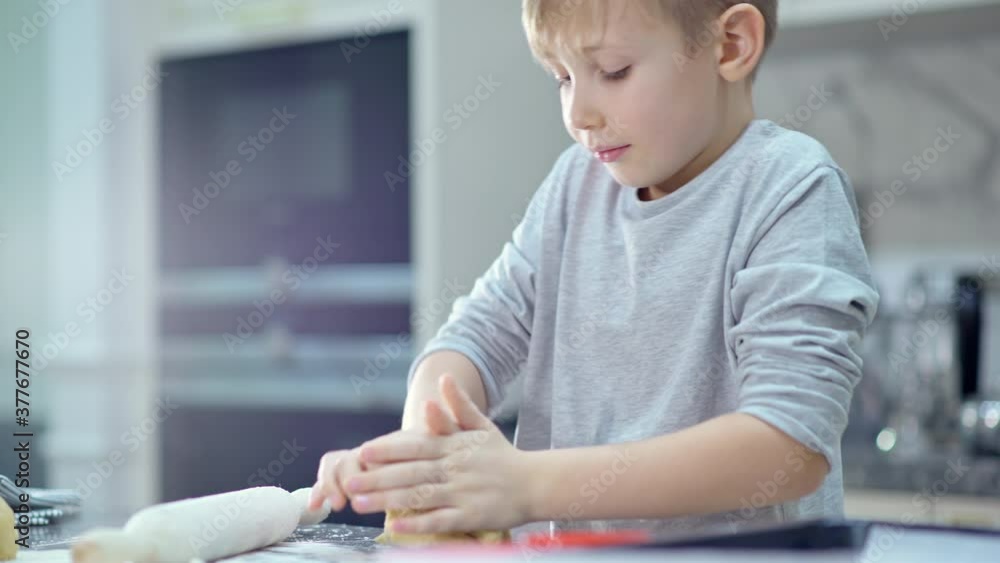 Child is stirring the dough in his hands. Boy is cooking in the kitchen. 8-year-old child cooks food at home. Slow motion 4k footage. Child is stirring the dough in his hands. Boy is cooking in the kitchen. 8-year-old child cooks food at home. Slow motion 4k footage.