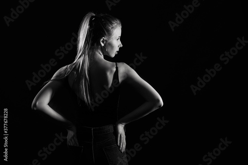 Girl on a black background in fashionable clothes