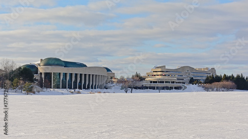 National history museum and surroundings along frozen Ottwa river covered with snow on a sunny cold winter day in Gatineau, Canada 