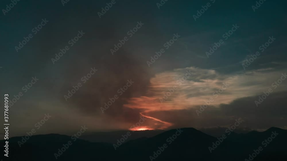 AERIAL: flying over housing in mountainous and dry terrain during a forest fire. AERIAL: flying over housing in mountainous and dry terrain during a forest fire.