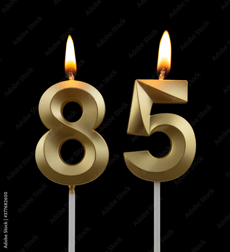 Burning golden birthday candles on black background, number 85 Burning golden birthday candles on black background, number 85