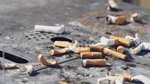 Cigarette butts on an ashtray waste bin	
 photo