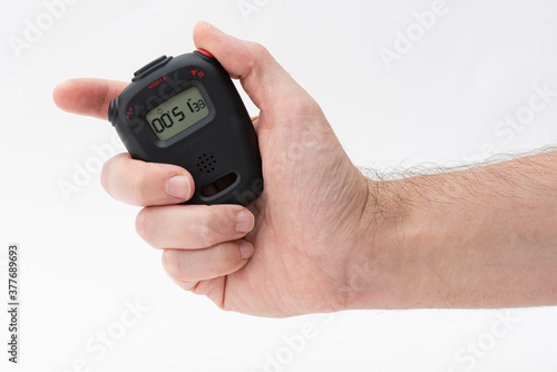 Man holding digital stopwatch on the white background.
