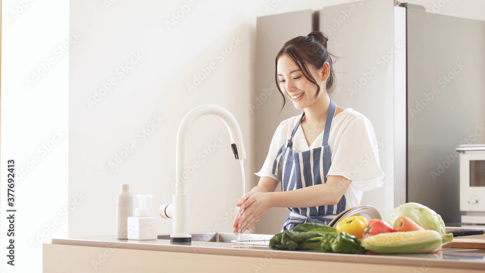 キッチンで手を洗う若い女性 キッチンで手を洗う若い女性