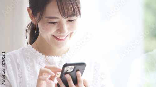 スマートフォンを操作している若い女性