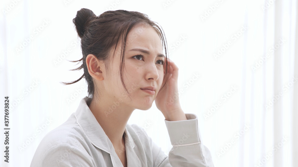 パジャマ姿の若い女性 頭痛 パジャマ姿の若い女性 頭痛