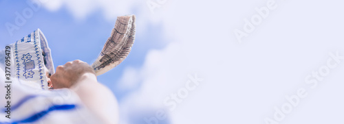 Happy Yom Kippur.Happy new year.Jewish man in Tallit blowing the Shofar (horn) of Rosh Hashanah (New Year Jew).Religious and Holidays in israel people of GOD.Peace Pray Freedom in Israel.Banner.