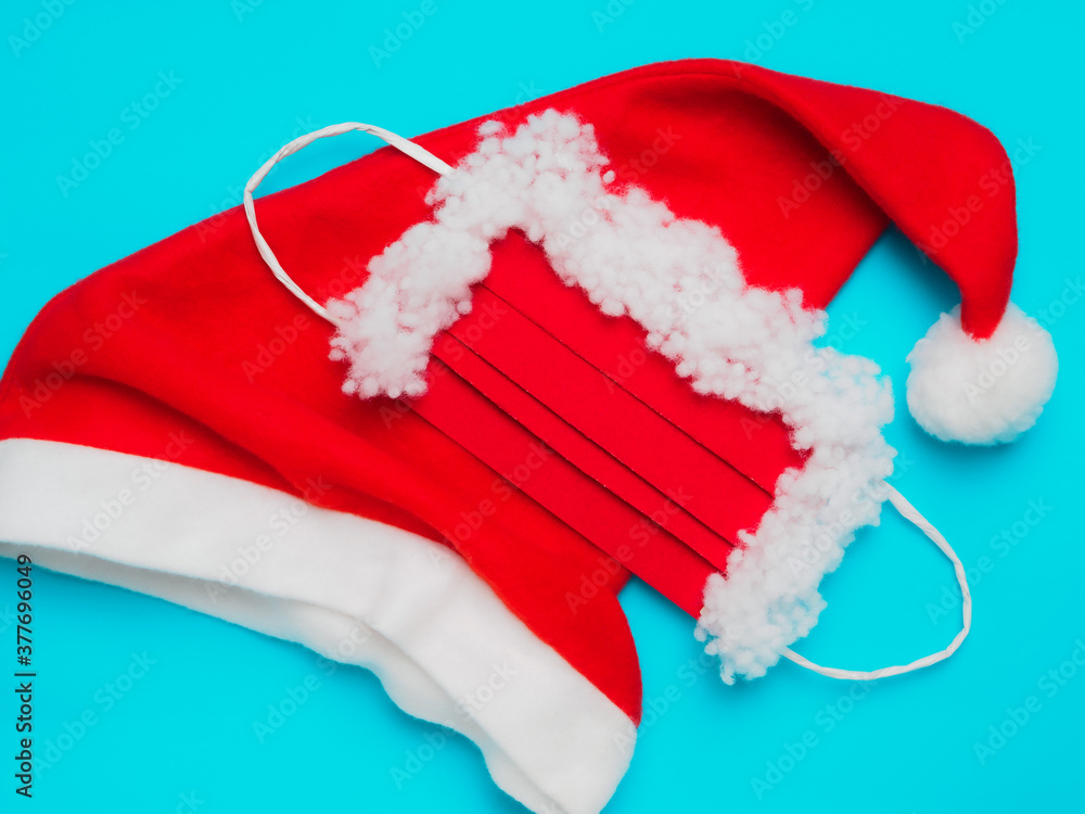 Santa Claus hat and protective mask, red and white, on a blue background Santa Claus hat and protective mask, red and white, on a blue background