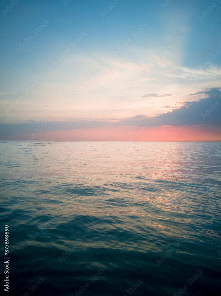 Obraz premium Pink sunset by the sea. Summer days. Foam waves. Beautifull.