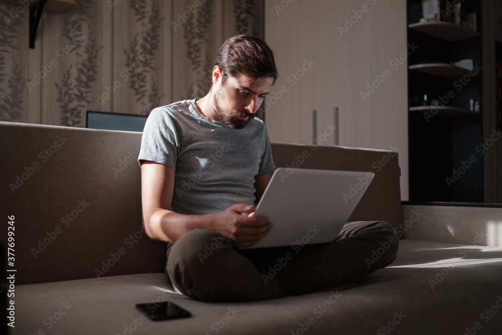Remote Job. Man Working On Laptop Sitting On Sofa At Home. Remote Job. Man Working On Laptop Sitting On Sofa At Home.