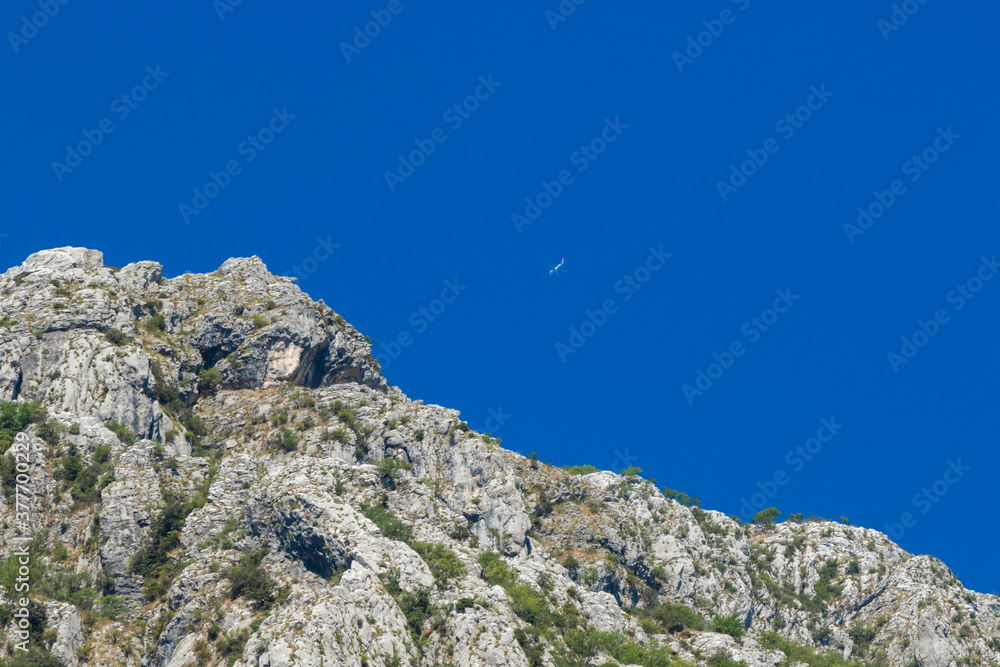 Airplane in the sky against the background of the mountain, very close