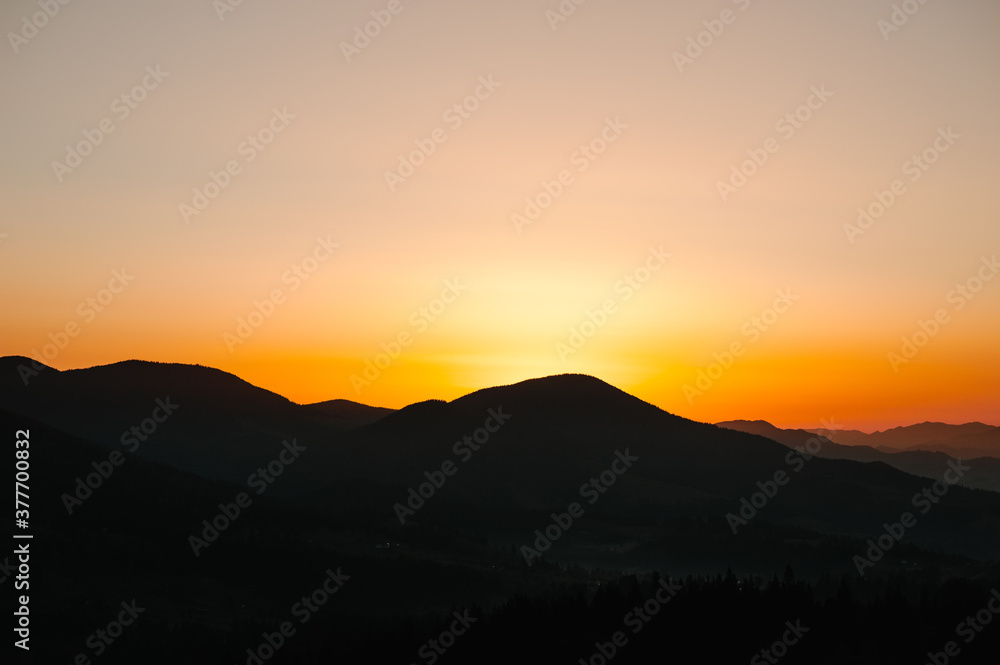 Silhouette of mountains at sunset or sunrise.