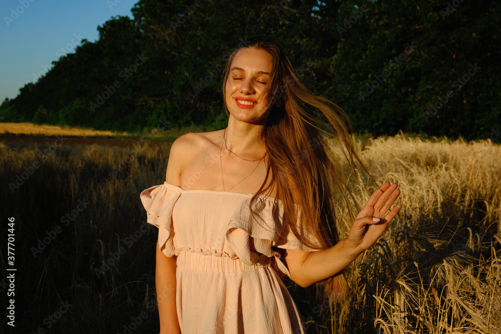 Obraz premium Digital Detox, Unplugging, Life, Offline, Sensitivity to nature, Mindfulness concept. Young blonde carefree wind long hair girl in blue linen dress enjoys life in the wheat field nature at sunset.