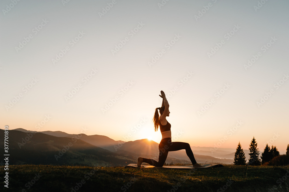 Silhouette woman balanced, practicing meditate and zen energy yoga in mountains. Healthy lifestyle concept. Young girl doing fitness exercise sport outdoors in landscape. Morning sunrise. Meditation.