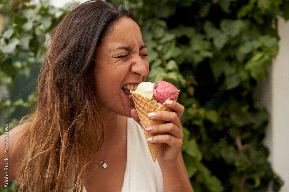 Woman eating ice cream outdoors. Summer concept. Woman eating ice cream outdoors. Summer concept.