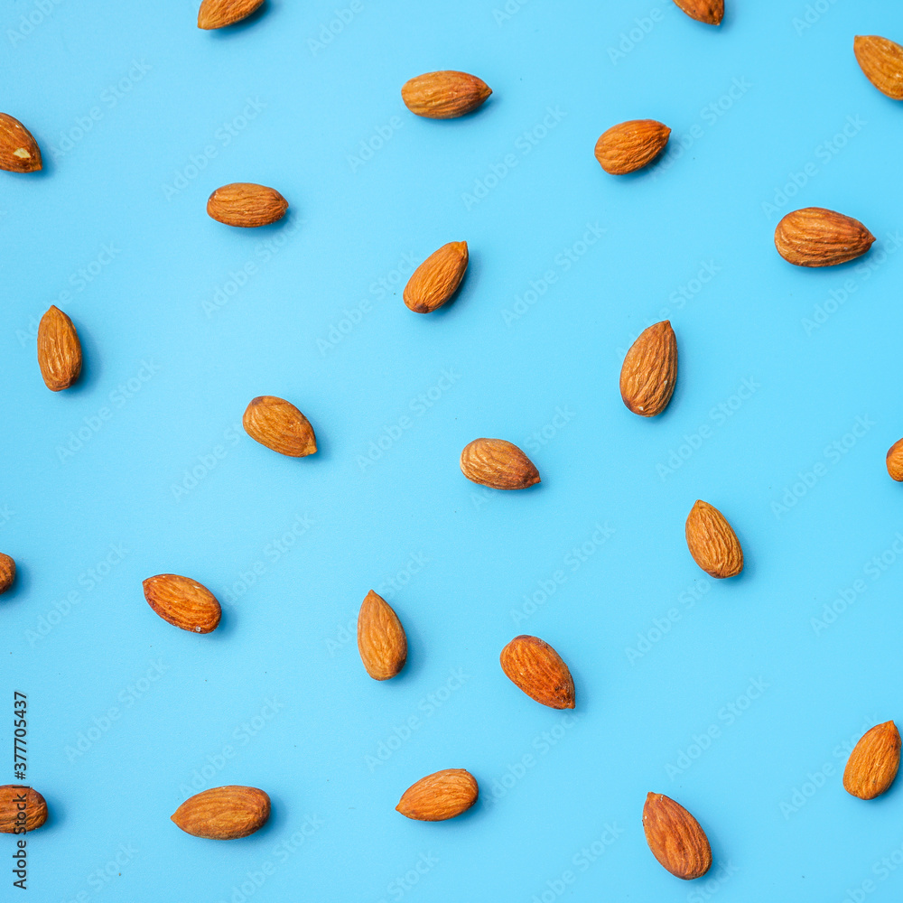 pattern of almonds arrange on blue background pattern of almonds arrange on blue background
